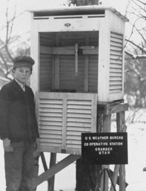 Young child standing next to an instrument shelter.